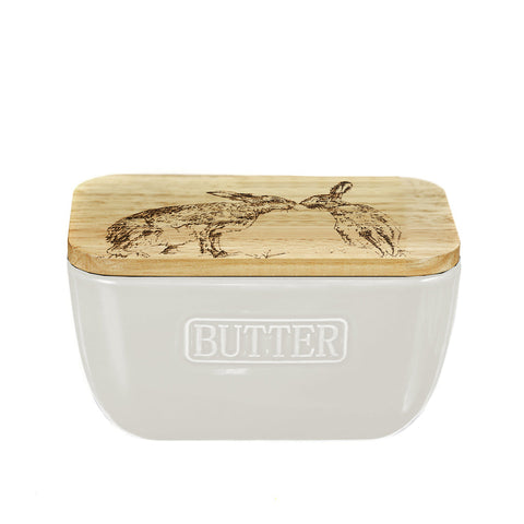 Cream-colored ceramic butter dish with natural wood lid engraved with kissing hare illustration for butter storage