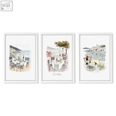 Set of three white-framed sole di amalfi kitchen paintings featuring mediterranean coastal dining scenes in watercolor