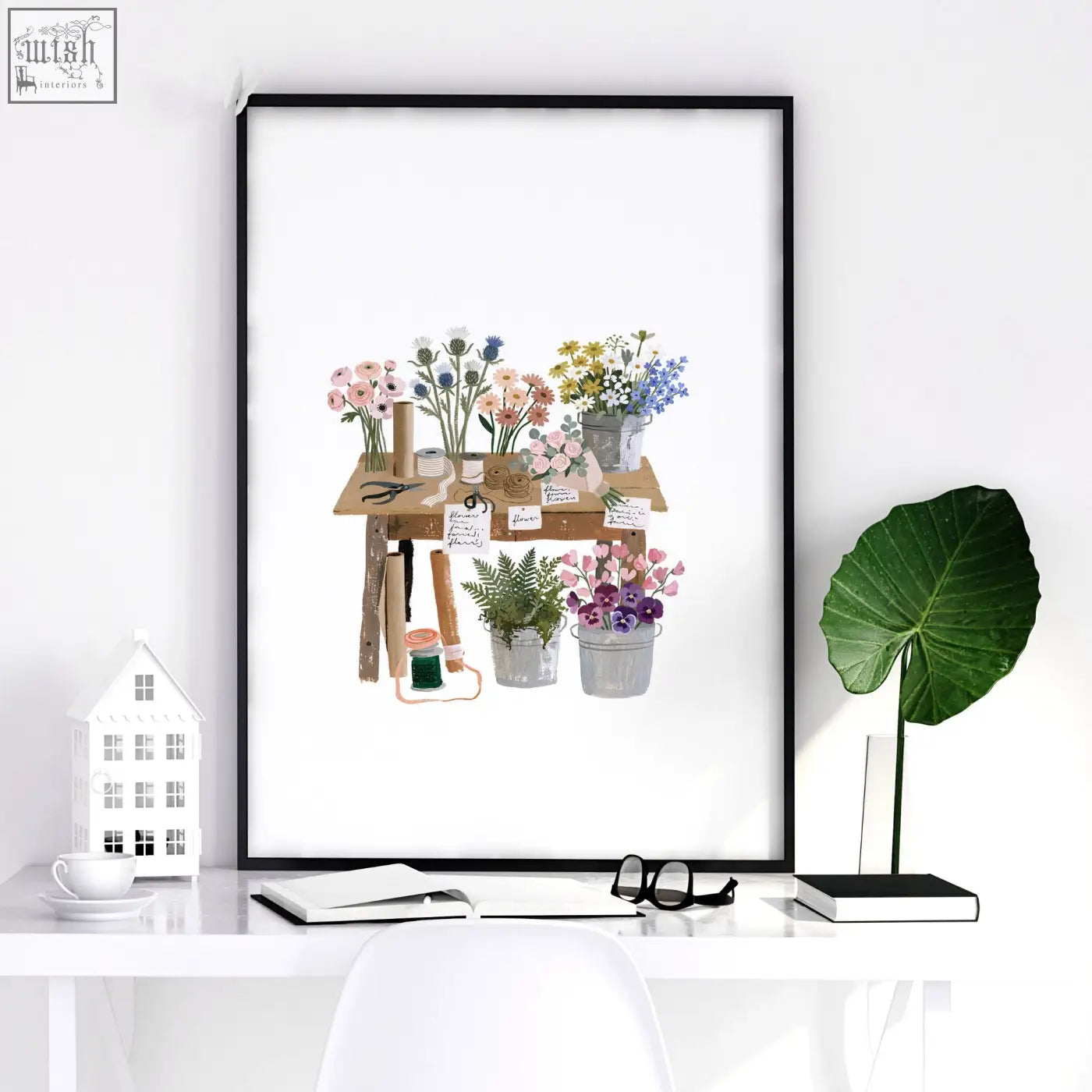Black-framed kitchen print showing a colorful flower shop floral arrangement station on a wooden table country cottage style