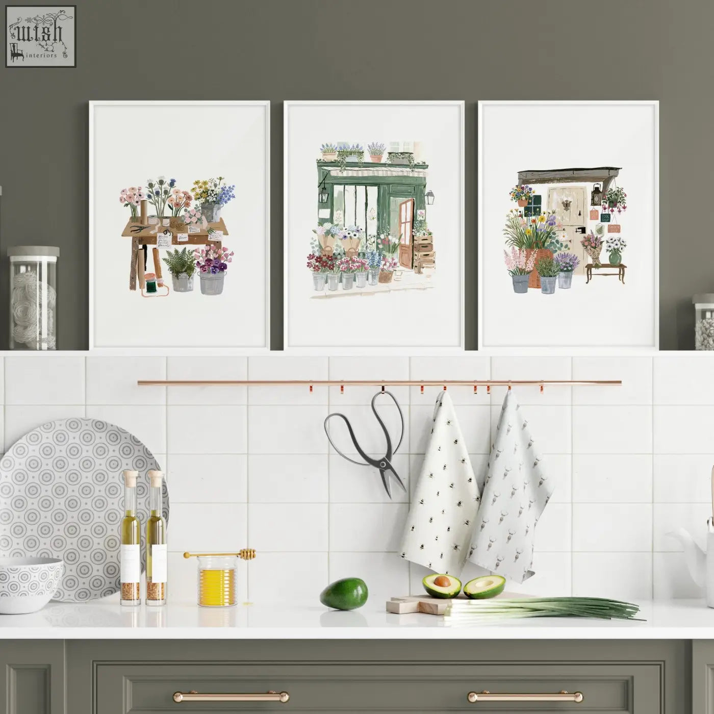 Three framed watercolor flower shop kitchen prints hang above a counter in a country cottage style kitchen