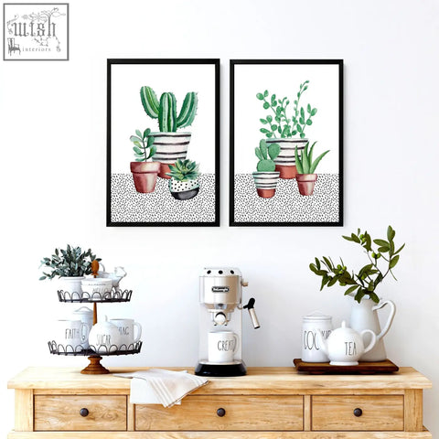 Silver delonghi espresso machine with black base and chrome accents next to kitchen prints featuring succulent plants wall art