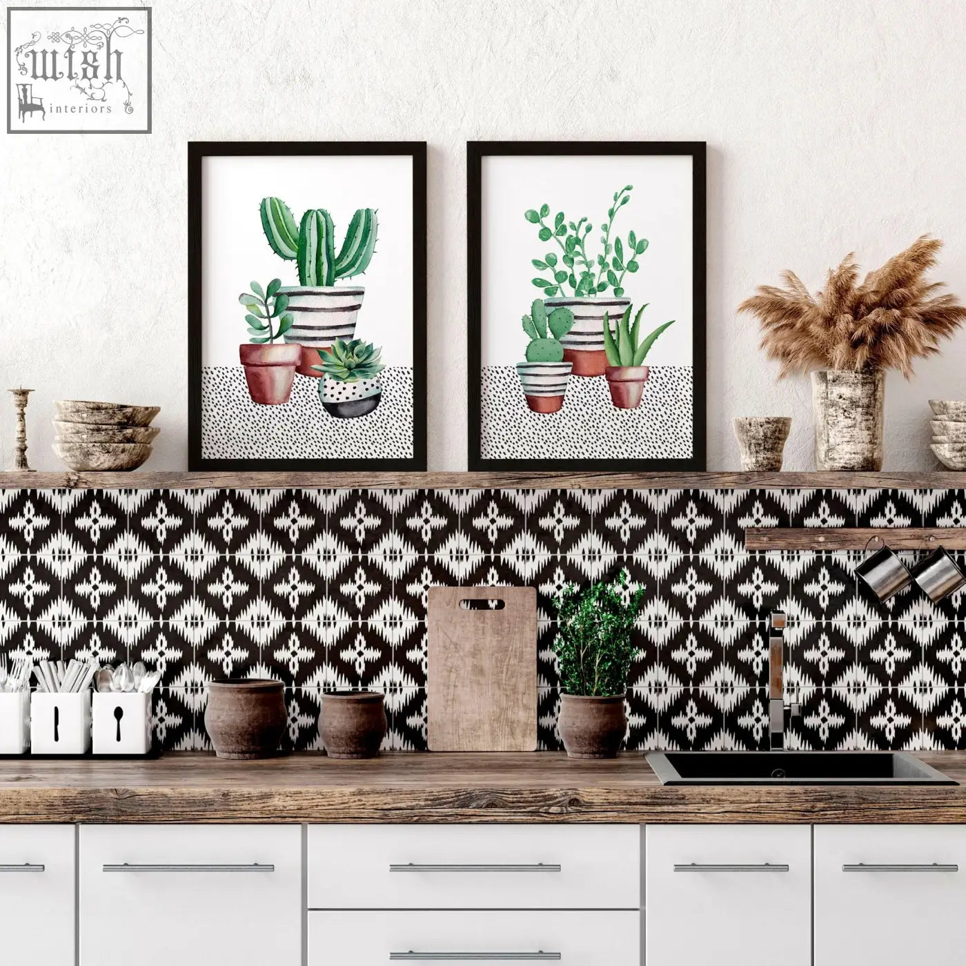 Two framed watercolor kitchen prints featuring succulent plants in striped pots above a black and white backsplash