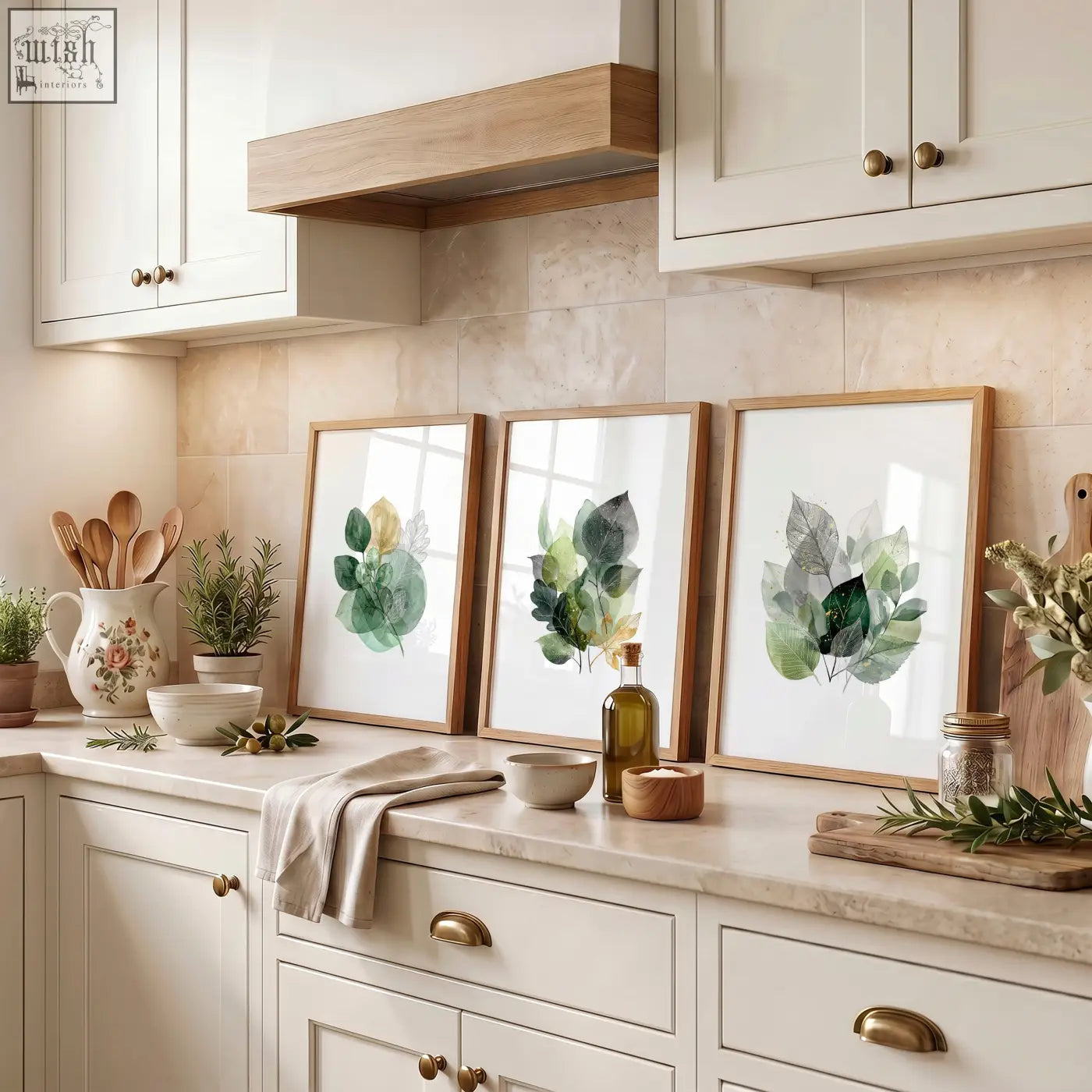 Three framed kitchen wall artwork prints featuring botanical watercolor leaves in green and gold tones with light wood frames