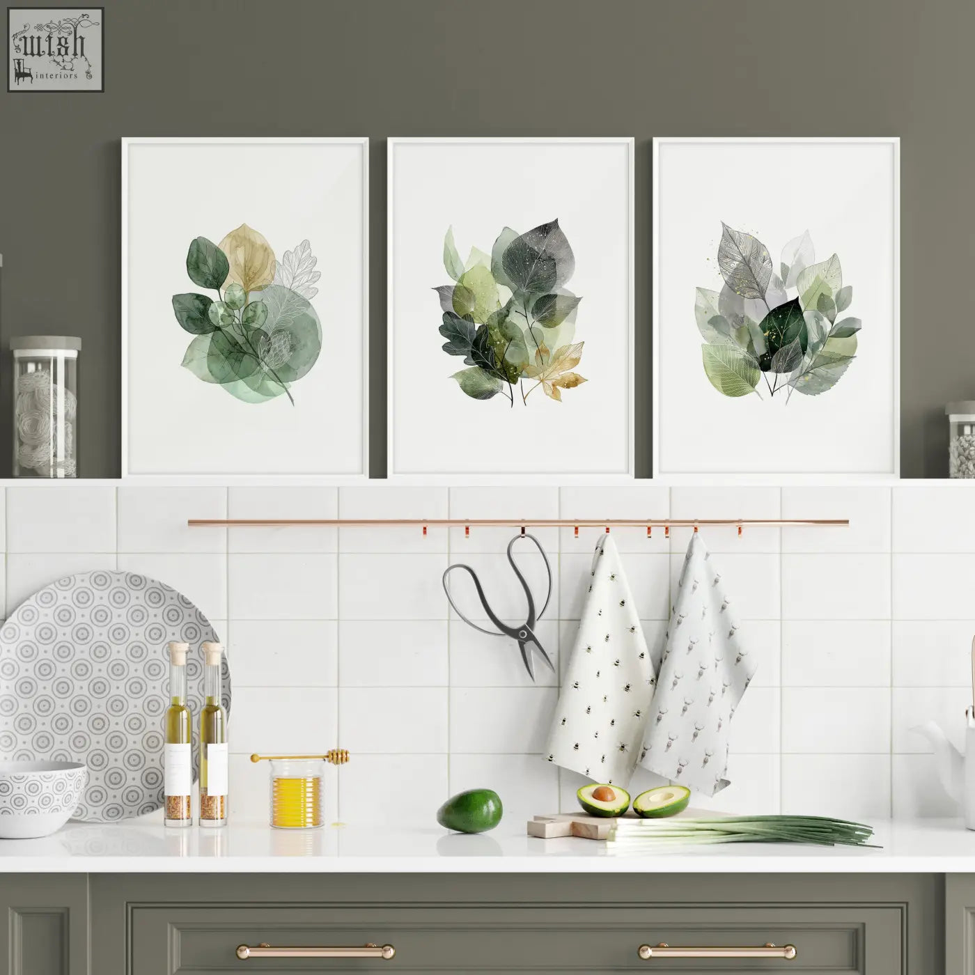 Three framed botanical kitchen wall artwork prints featuring green leaves with gold tones in white frames