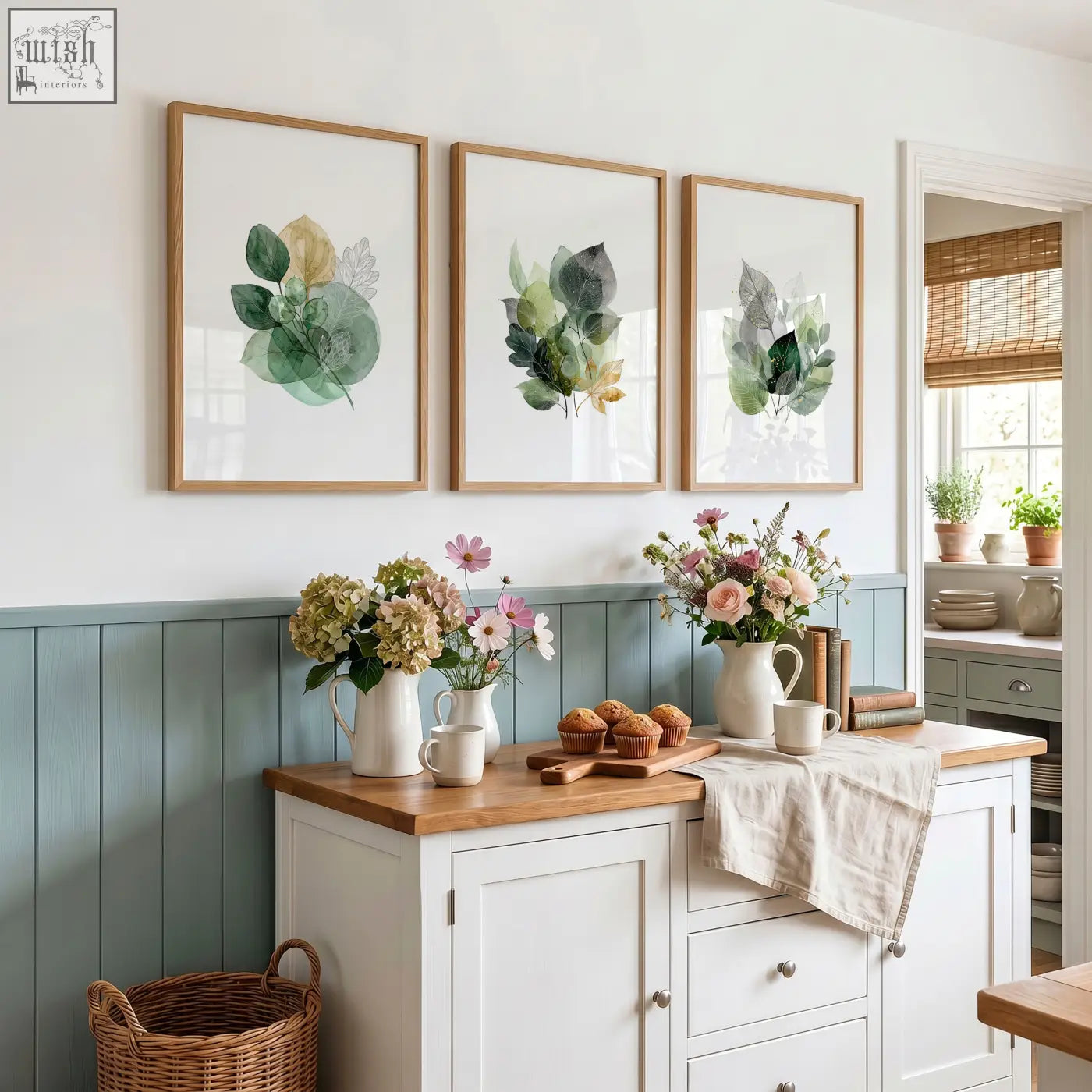Set of three kitchen wall artwork with botanical watercolor leaves in soft greens and gold tones in light wood frames