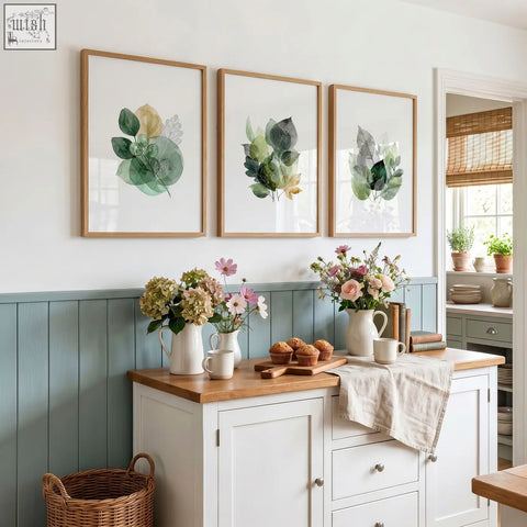 Set of three kitchen wall artwork with botanical watercolor leaves in soft greens and gold tones in light wood frames