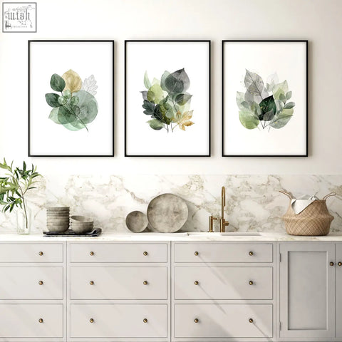 Three framed botanical prints with watercolor leaves in muted greens and gold tones perfect for kitchen wall artwork