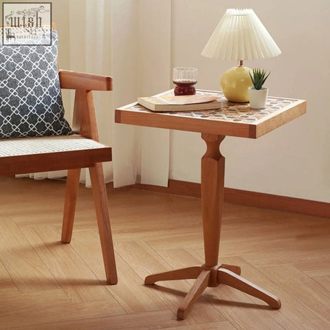 A square kitty side table with a cherry wood pedestal base and mosaic tile top in warm tones