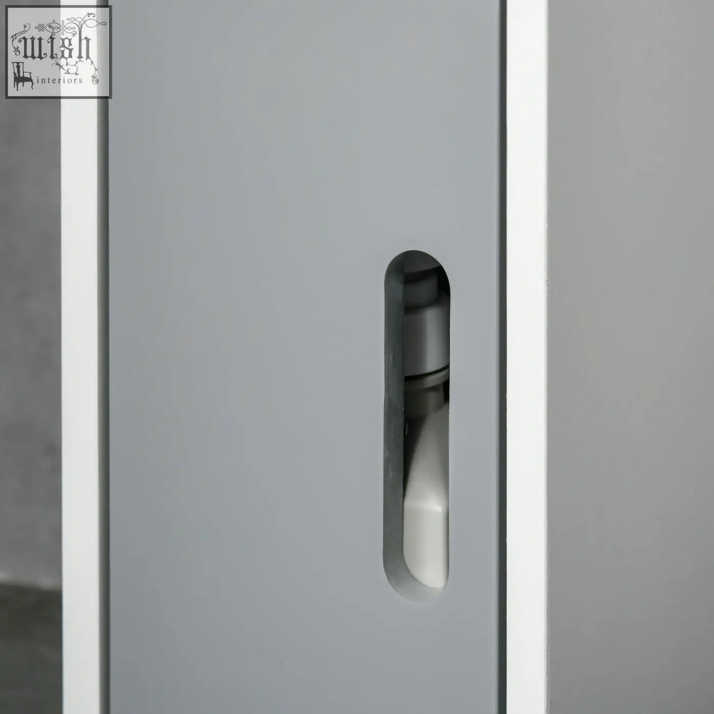 Gray metal bathroom storage cabinet with open shelves and door showing a white pump bottle inside