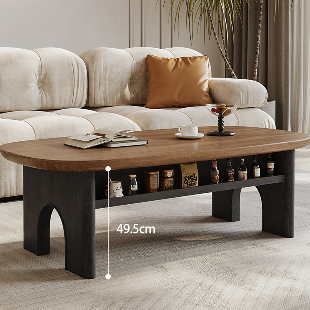 Modern knight coffee table with warm wood oval top and black arched legs featuring open storage shelf beneath