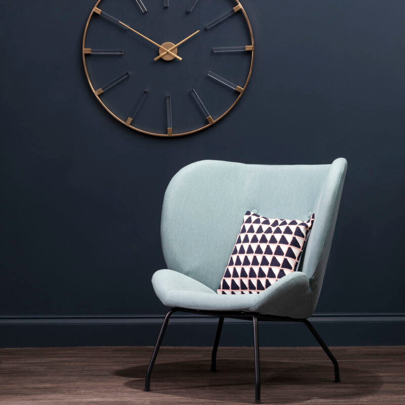 Light blue velvet kolding green fabric accent chair with black metal legs and geometric-patterned pillow