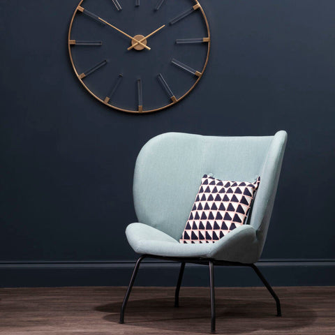 Light blue velvet kolding green fabric accent chair with black metal legs and geometric-patterned pillow