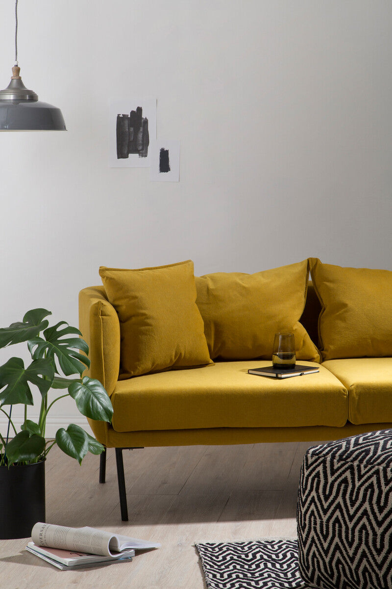 A vibrant mustard-yellow velvet kolding two seater sofa with sleek black metal legs and matching cushions