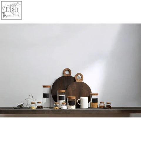 Set of minimalist ceramic mugs with wooden lids and handles beside a white and black striped mango wood chopping board