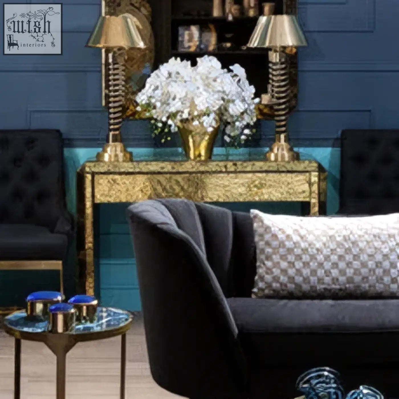 Black velvet sofa with a gray and white patterned cushion next to a komo console table in a modern living room