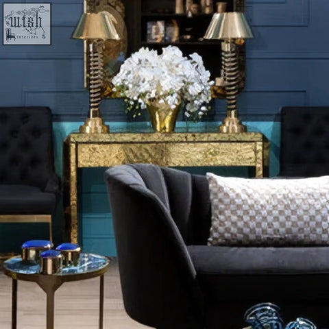 Black velvet sofa with a gray and white patterned cushion next to a komo console table in a modern living room