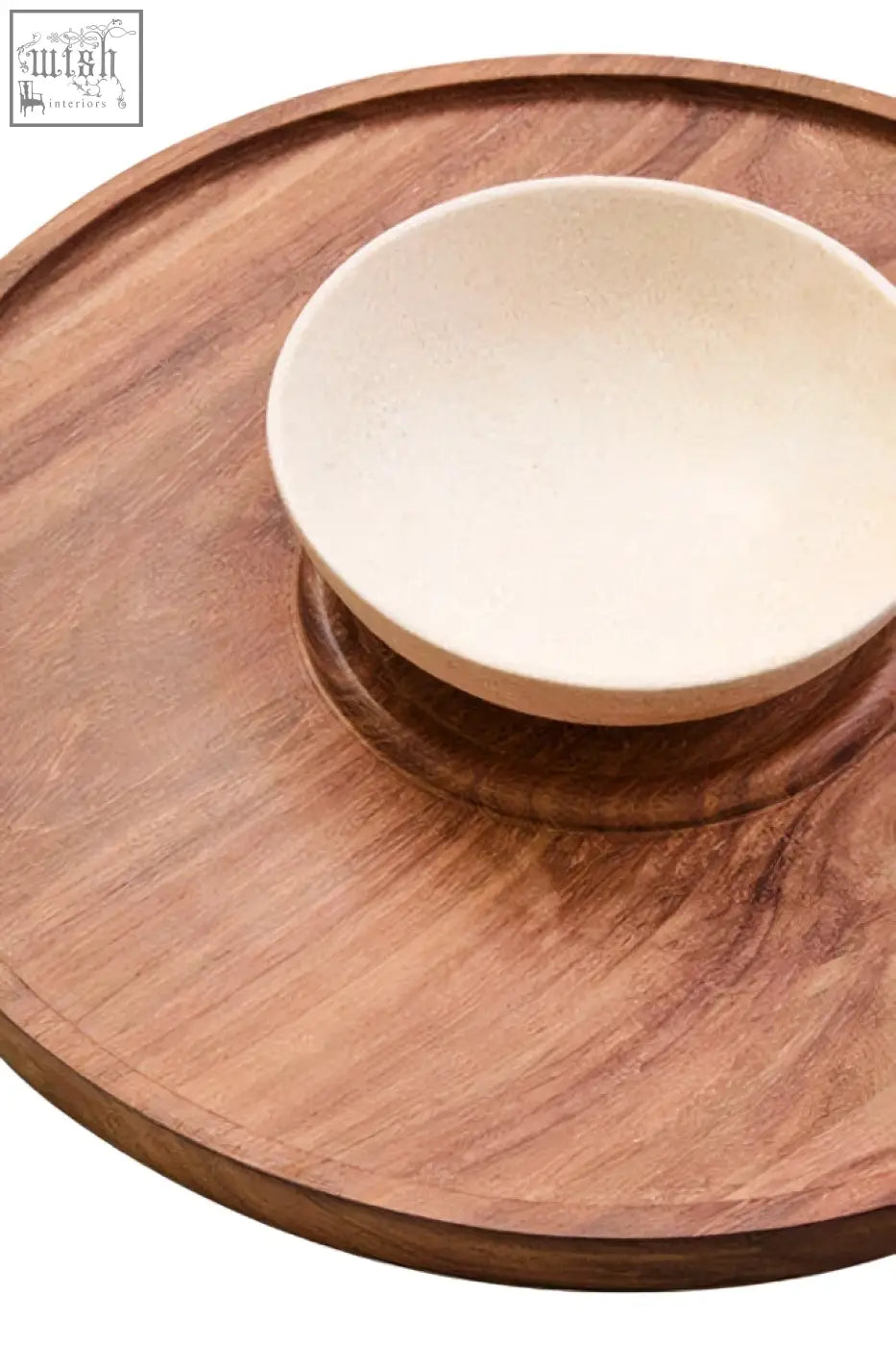 A beige ceramic bowl on a cream marble chip and acacia wood circular chip and dip platter tray