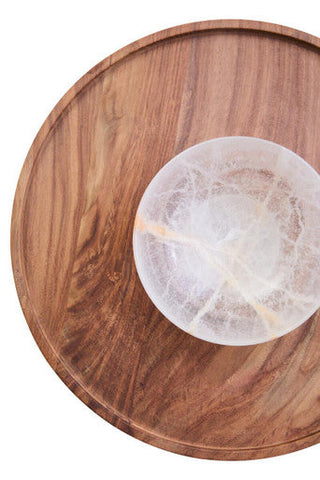 A translucent white and pale yellow selenite bowl with natural patterns on a kora acacia wood and onyx chip dip platter
