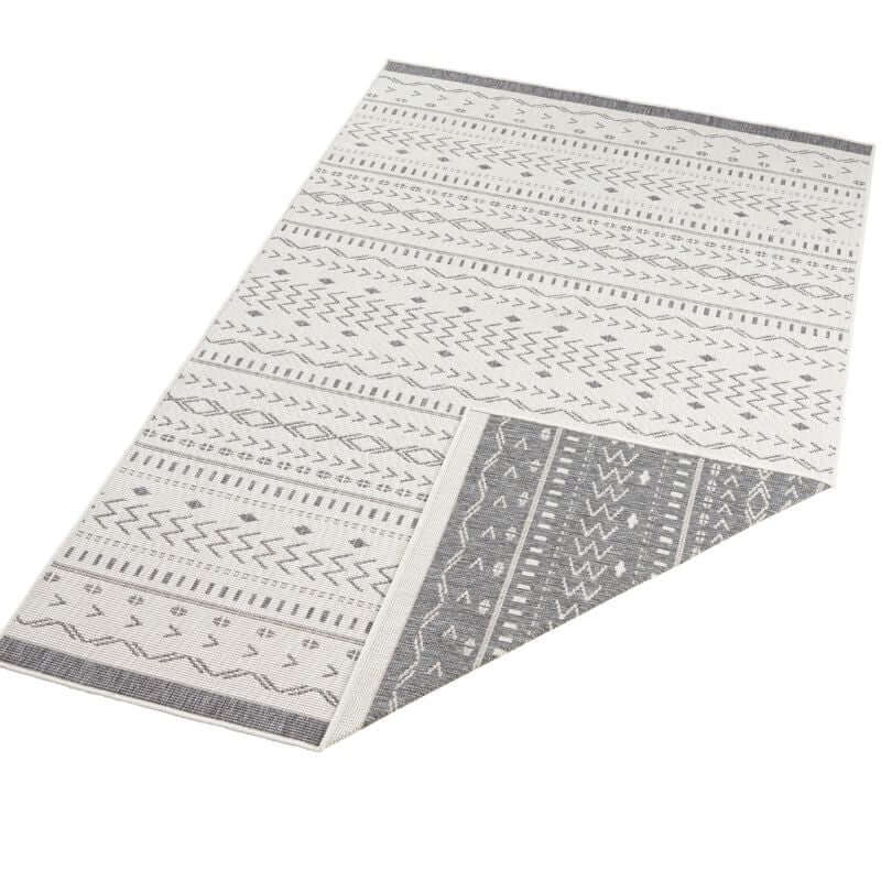 A kuba reversible indoor-outdoor rug with a cream base and intricate gray geometric woven patterns