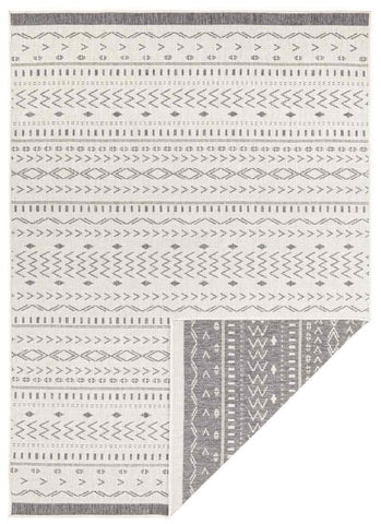A kuba reversible indoor outdoor rug with a gray and white geometric tribal pattern on a rectangular surface