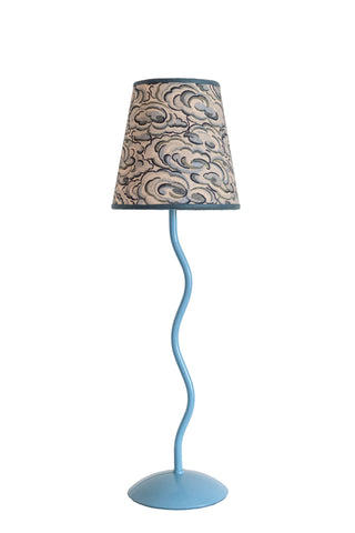 A light blue wavy metal floor lamp with a beige and gray kumo clouds lampshade featuring an intricate cloud pattern
