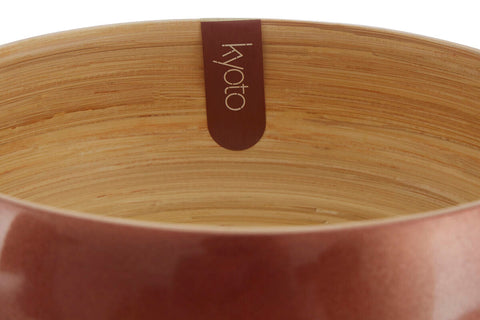 A sleek medium rose gold bamboo bowl with a warm terracotta exterior and natural wood grain interior