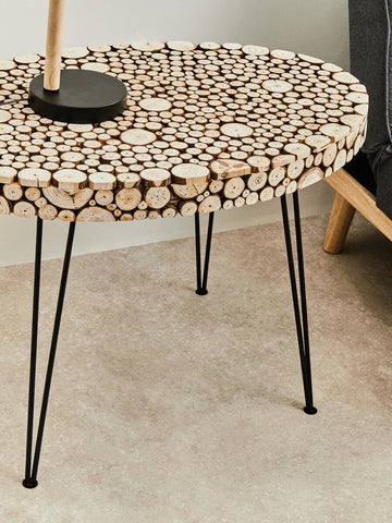 Lacuna fir wood oval coffee table with round top of natural wood slices in light brown and beige tones on black hairpin legs