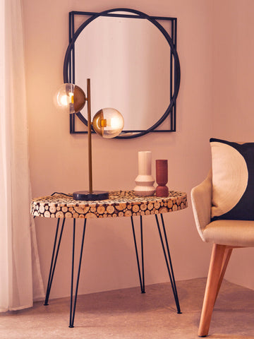 A round mirror with a black geometric frame paired with lacuna fir wood oval coffee table design