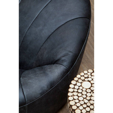 Black leather armchair with curved segmented design shown next to lacuna fir wood round side table