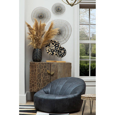 Black leather pouf with quilted texture and rounded shell shape paired with lacuna fir wood round side table
