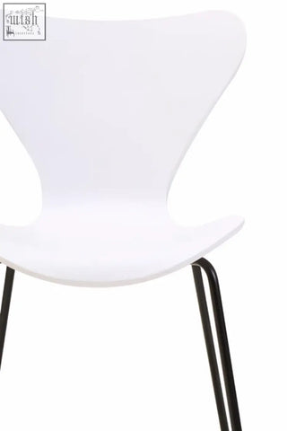 White molded plastic dining chair with sleek black angular legs and a white undulating seat design