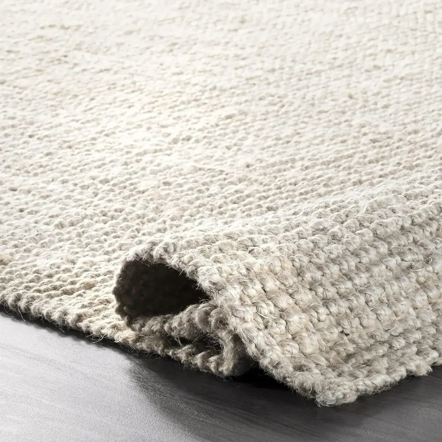 Beige textured wool lamion rug with chunky hand knitted weave and slightly frayed edges