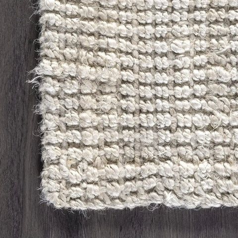 Beige lamion rug with a textured braided pattern and frayed edges perfect for cozy home decor