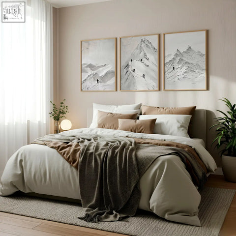 A cozy bed with beige and brown bedding and a gray throw in a room featuring nordic mountain climbers wall art prints