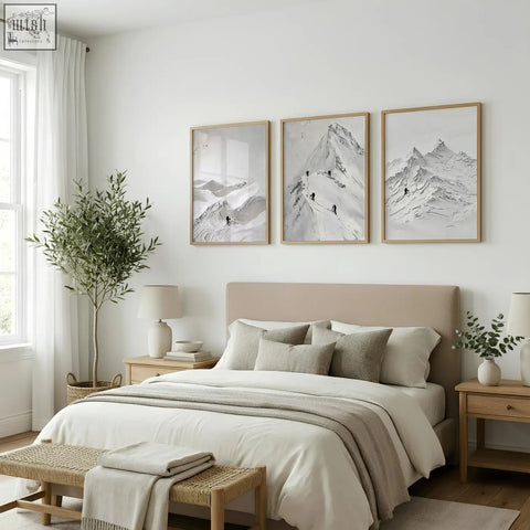 Beige upholstered bed with matching pillows and neutral throw blanket below landscape art nordic mountain climbers wall art prints set of 3