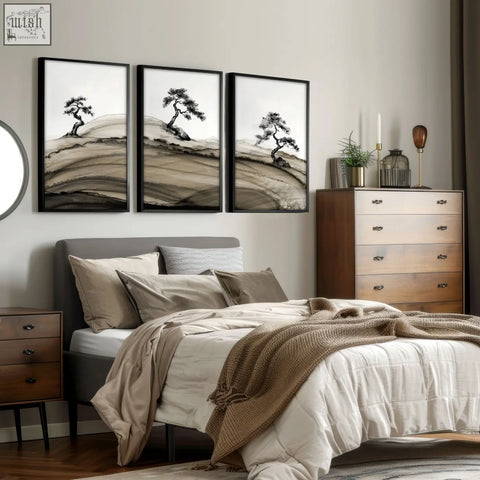 Three framed black-and-white japanese ink landscape prints of bonsai pine trees on rolling hills above a bed