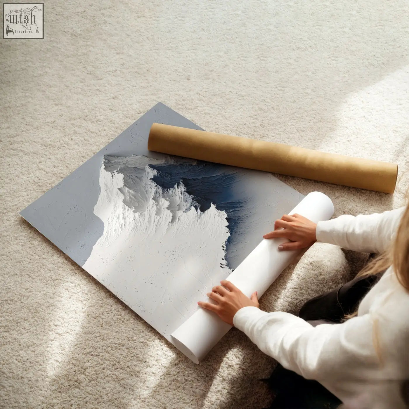 A modern abstract landscape wall art with textured white and deep blue brushstrokes on gray canvas beside brown paper roll