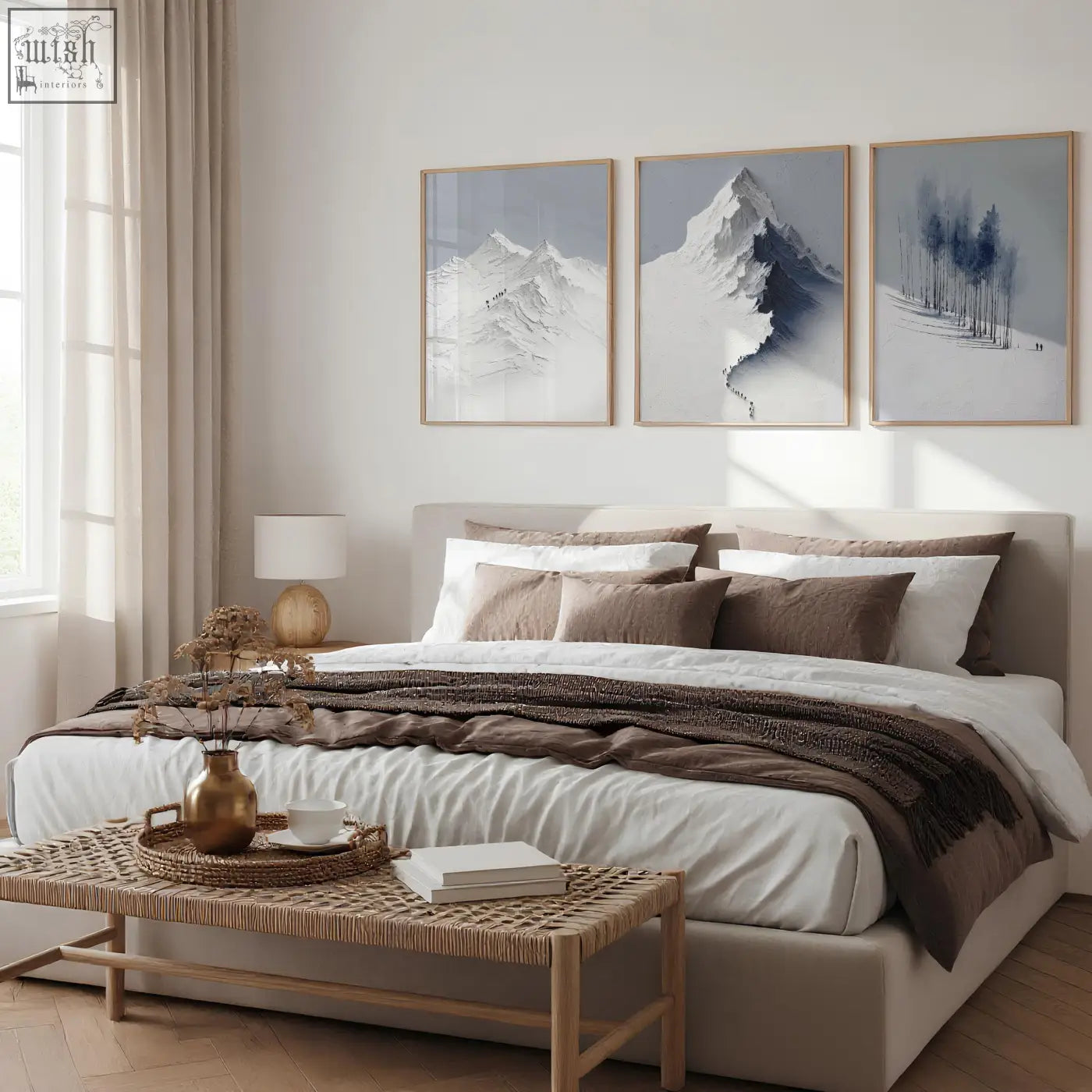 Beige upholstered bed with layered white and brown bedding below nordic snow mountains landscape wall art set of 3