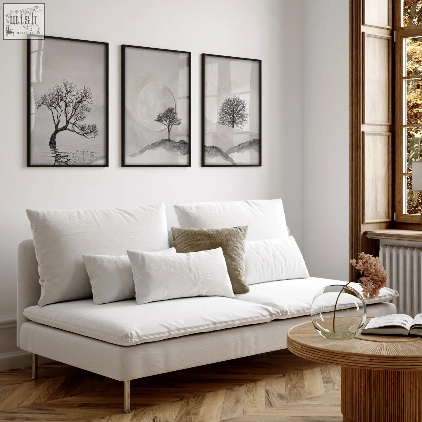White upholstered sofa with metallic legs and cushions in living room featuring large 3 piece wall art of nordic trees and moon