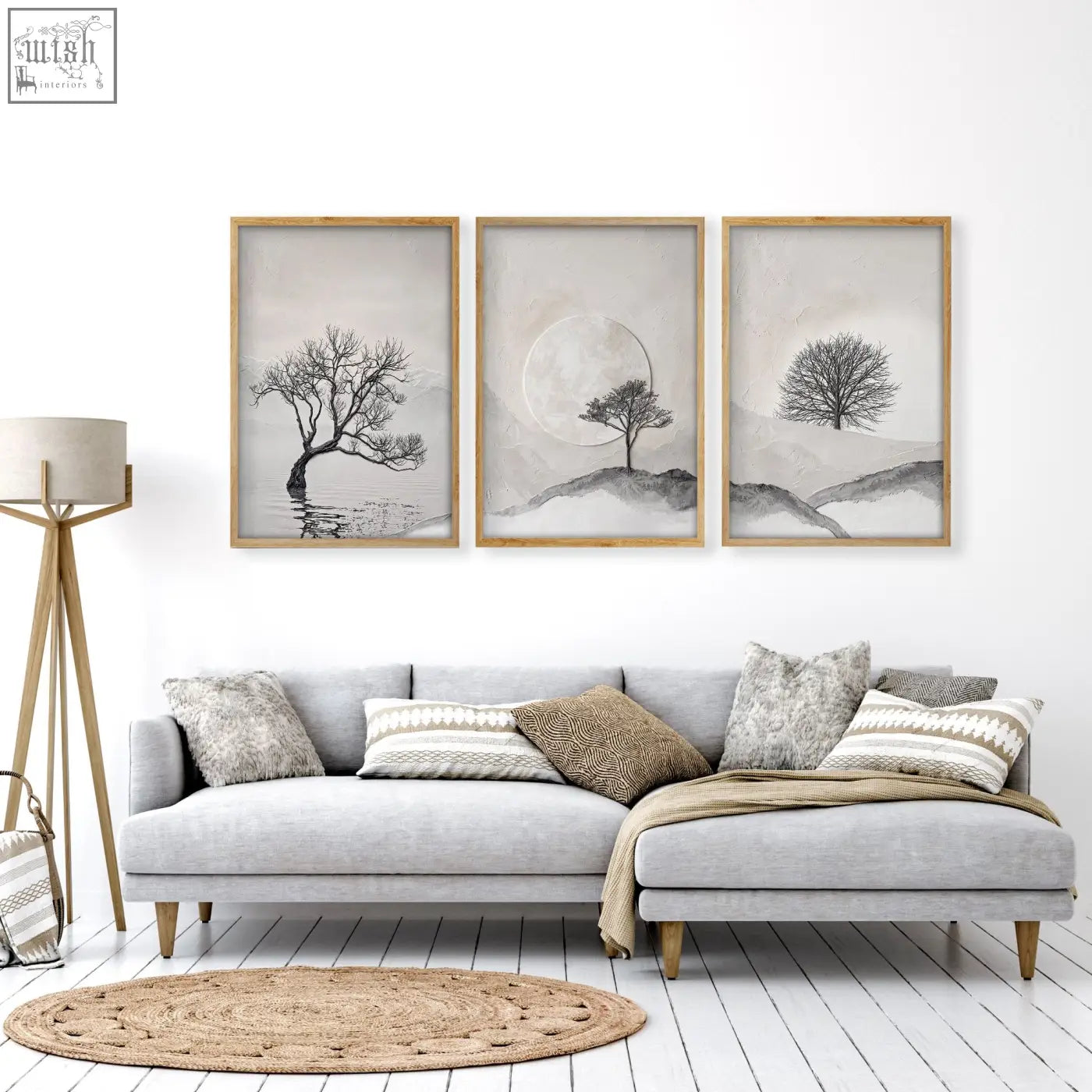 Three piece black and white tree wall art with light wood frames above a gray sectional sofa for living room decor