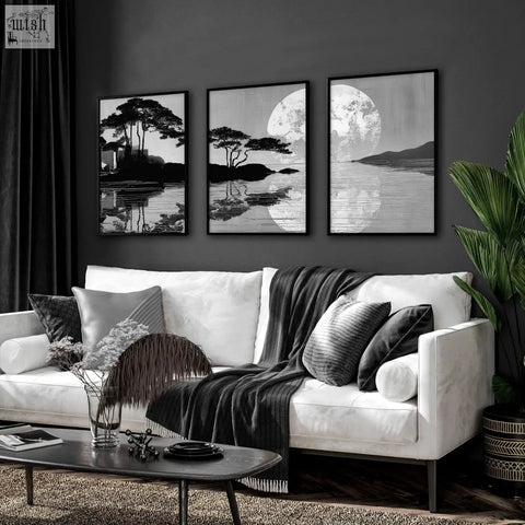 Three black-framed large art living room prints of japanese moonrise silhouette with trees and water reflections above sofa