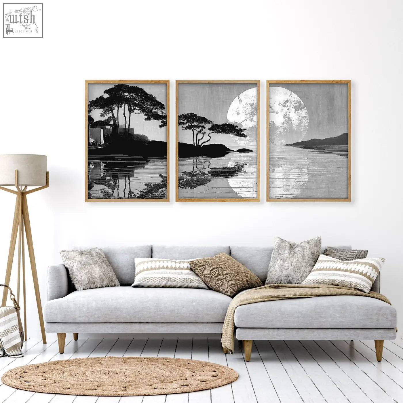 Three framed black and white japanese moonrise silhouette prints with wooden frames hang above a gray sectional sofa in a large art living room setup