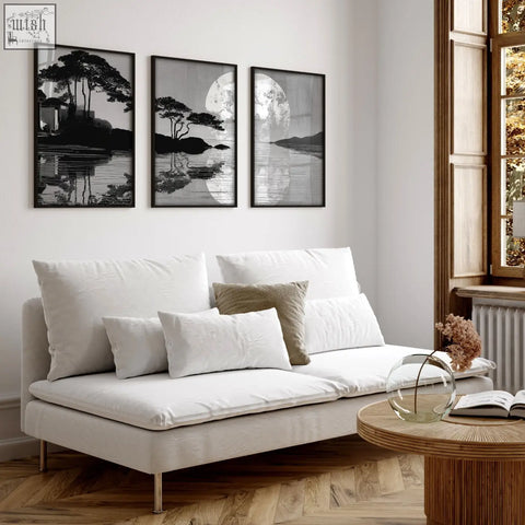 White upholstered sofa with metallic legs and cushions paired with large art living room japanese moonrise silhouette prints set of 3