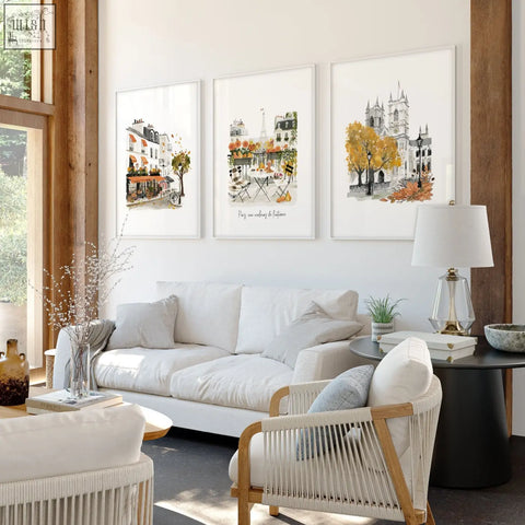 Three large autumn paris watercolour prints framed above a white sofa for living room wall decor