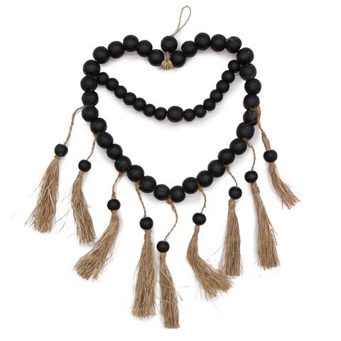 Large bead heart mobil made of black wooden beads with natural jute tassels measuring 33x23cm