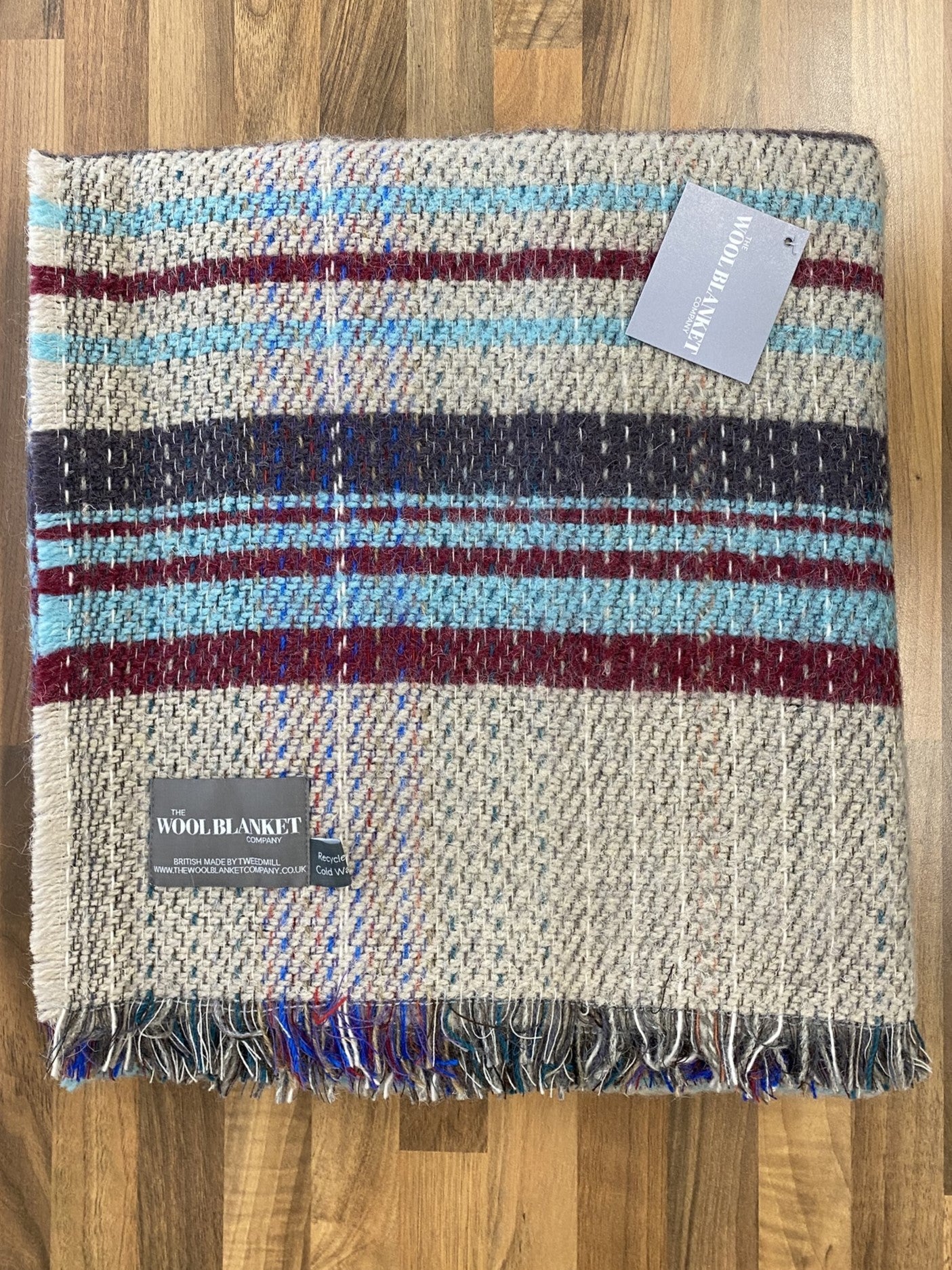 Large checked random recycled wool blanket with horizontal beige, blue, red, and navy stripes and fringed edge