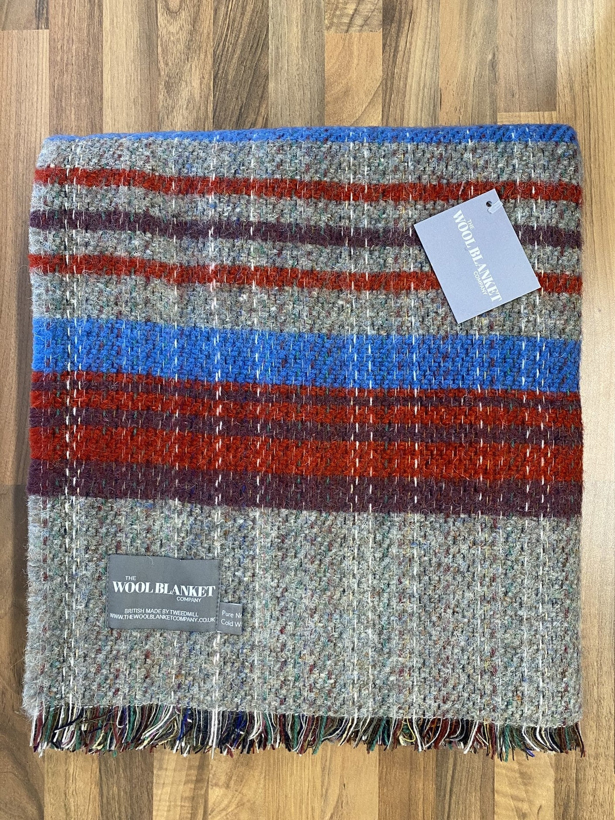 Large checked random recycled wool blanket with bold gray red blue maroon stripes and textured fringe edges