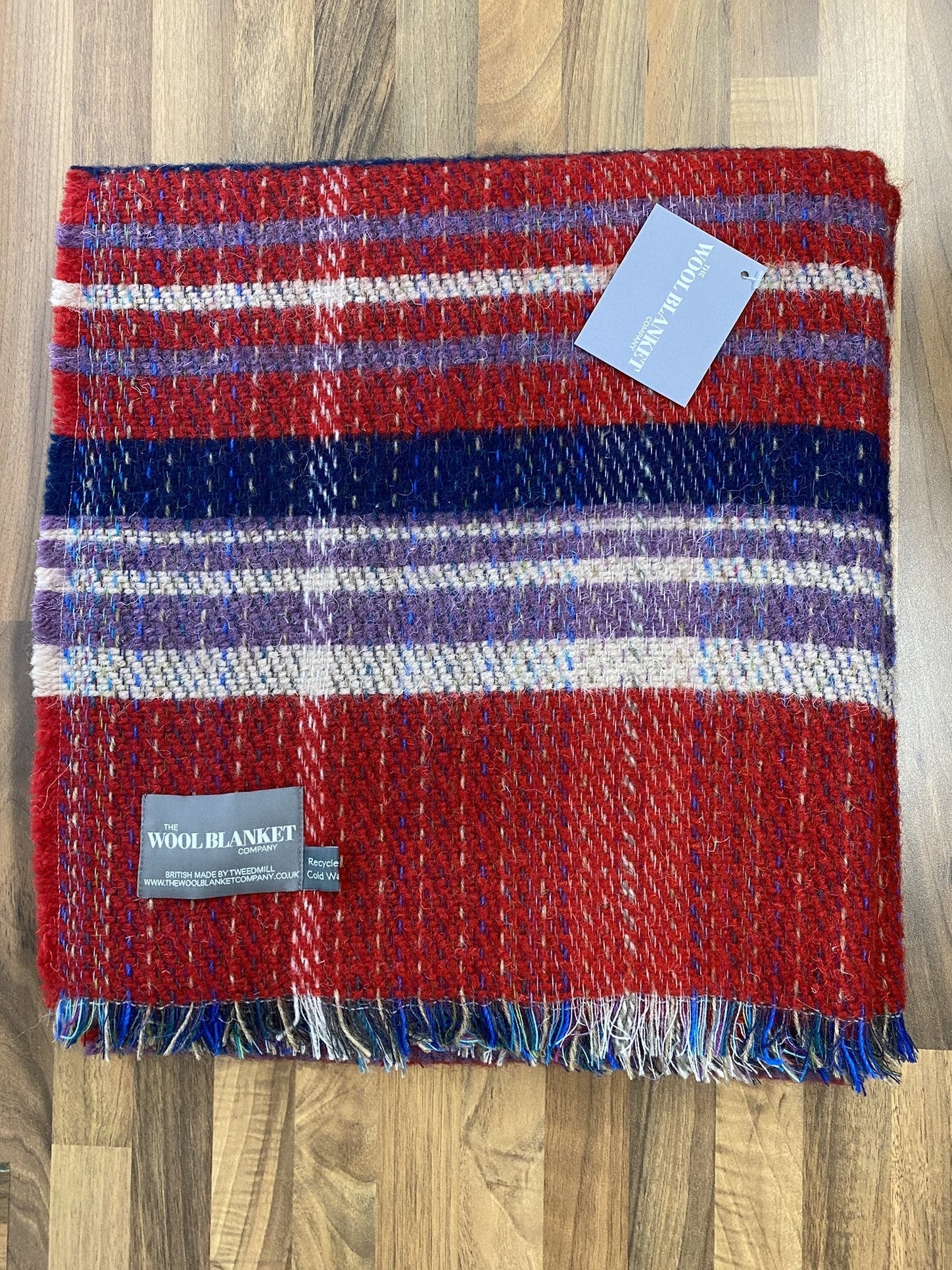A cozy large checked random recycled wool blanket with bold red navy and white stripes and textured fringe
