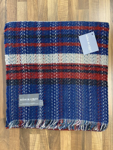 A cozy large checked random recycled wool blanket in blue red and white plaid with fringed edges from the wool blanket company