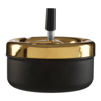 Large gold and matte black spinning ashtray with a central black cylindrical cigarette holder and matte black finish